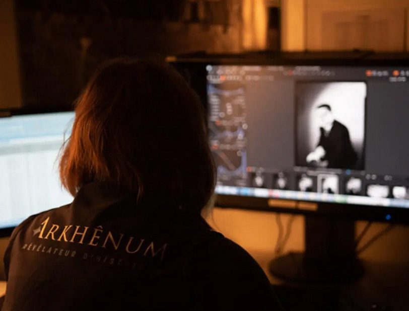 Stéphanie Cousin restoring damaged archival images at Arkhênum, revealing hidden historical details.